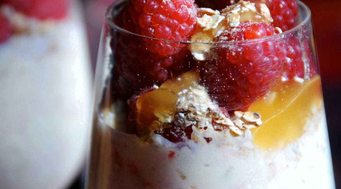 Traditional Cranachan dessert with raspberries, whipped cream, honey, and toasted oats