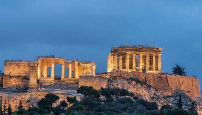 The Acropolis of Athens, Greece, featuring the Parthenon with its classical Doric columns at sunset.