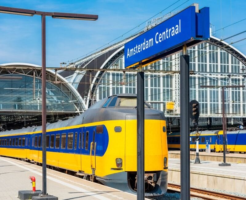 A train at Amsterdam Central Station, ready for departure, showcasing the station's architectural beauty and the efficiency of European rail travel.