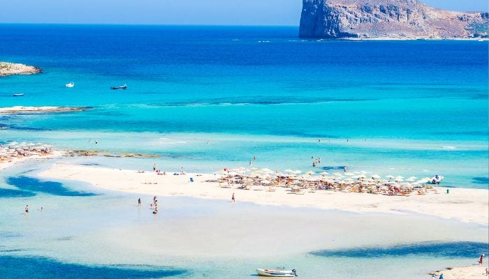 A beautiful beach on Crete, Greece, with golden sand and clear turquoise waters.