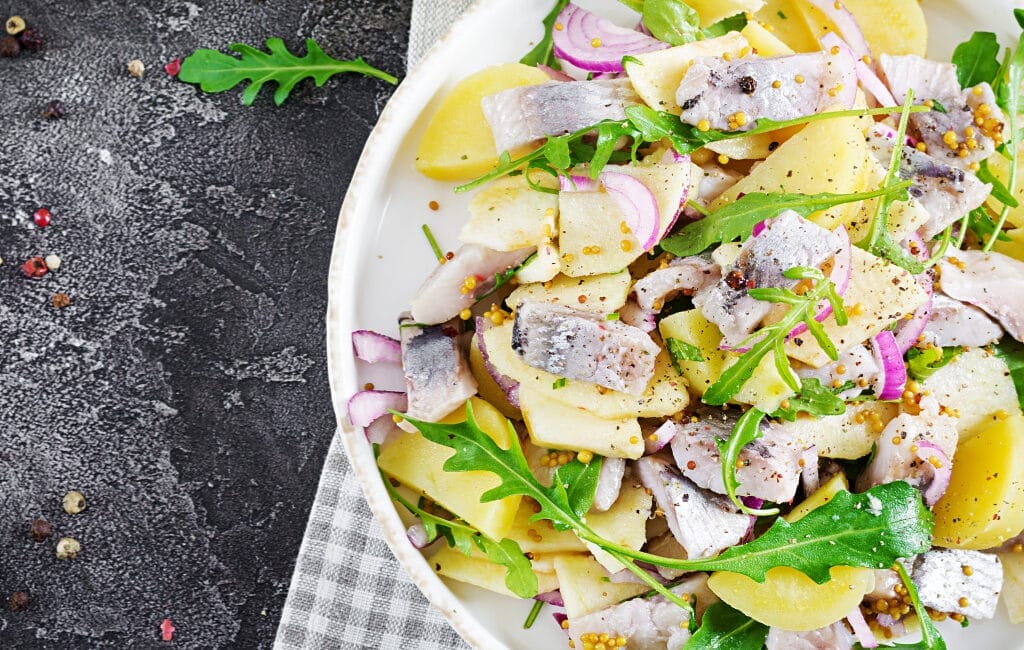 Traditional German Matjes Salad with marinated herring, onions, and apples