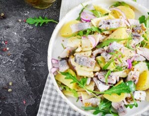 Traditional German Matjes Salad with marinated herring, onions, and apples