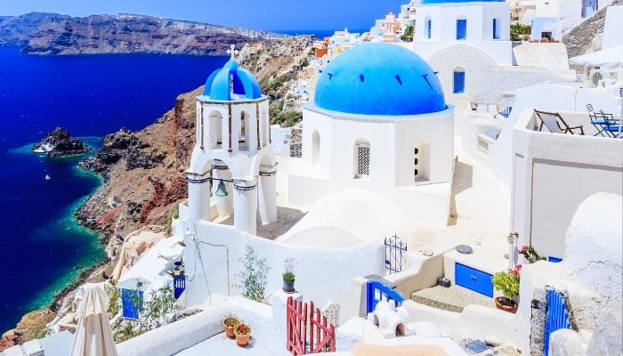 A stunning view of Santorini, Greece, with its iconic white-washed buildings and blue domes overlooking the Aegean Sea.