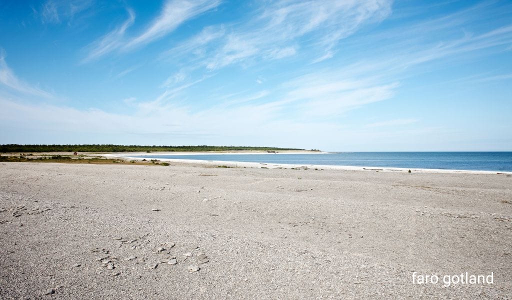 Expansive sandy beach on Fårö, Gotland, Sweden, with clear blue skies and gentle waves