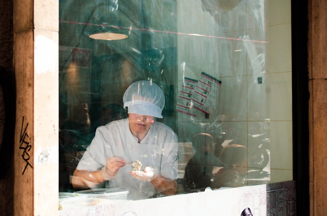 Chef preparing food behind a street window, illustrating mealtime customs