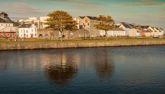 The stunning waterfront of Galway, Ireland, offers beautiful views of boats and historic buildings, perfect for a relaxing getaway.